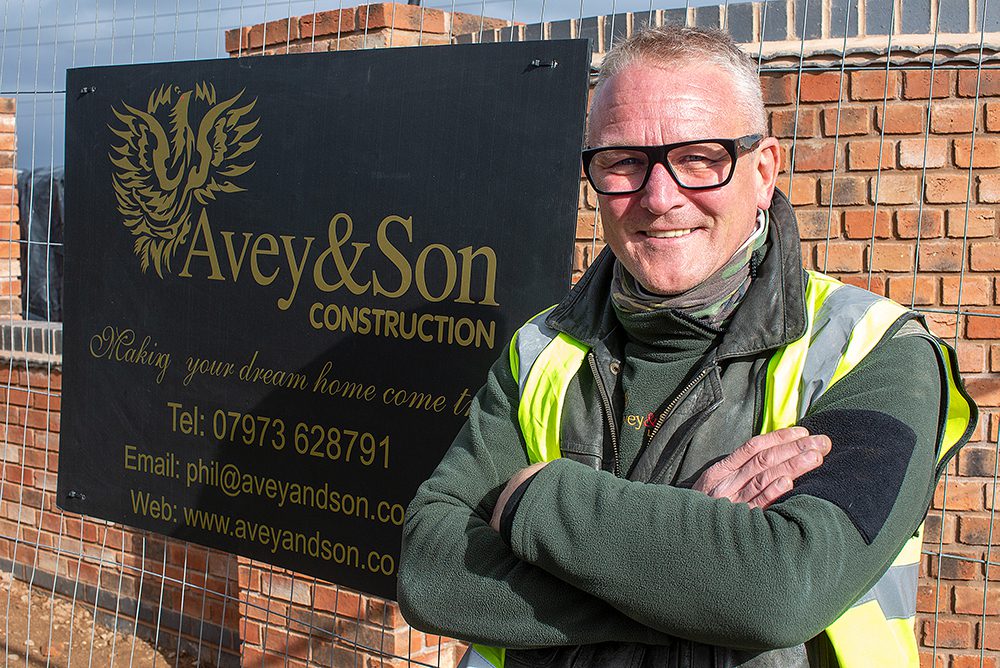 Phil Avey standing beside contact details board outside development